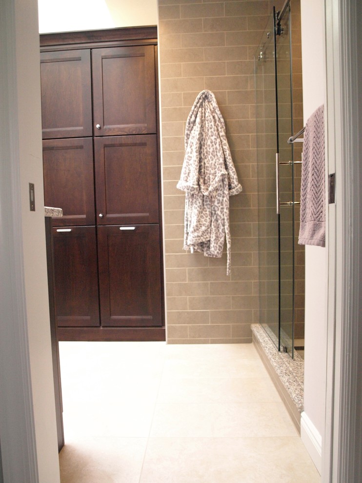 This is an example of a large classic ensuite bathroom in Newark with flat-panel cabinets, brown cabinets, an alcove shower, beige tiles, ceramic tiles, a submerged sink, granite worktops, a sliding door, a two-piece toilet, beige walls, porcelain flooring and beige floors.