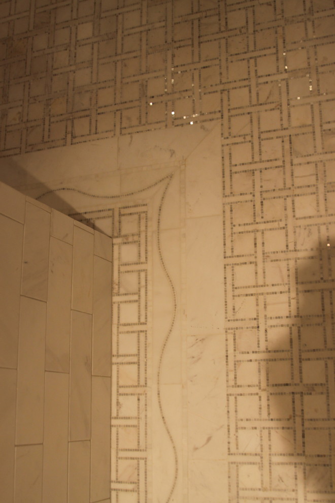 Inredning av ett klassiskt mellanstort en-suite badrum, med ett fristående handfat, luckor med profilerade fronter, beige skåp, marmorbänkskiva, ett fristående badkar, en dusch/badkar-kombination, en toalettstol med hel cisternkåpa, flerfärgad kakel, stenkakel, grå väggar och marmorgolv