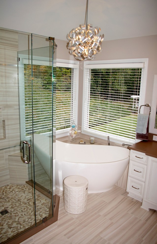 Photo of a large traditional ensuite bathroom in Atlanta with a submerged sink, white cabinets, limestone worktops, a freestanding bath and raised-panel cabinets.