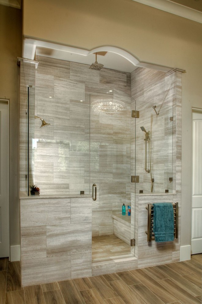 Design ideas for a large classic ensuite bathroom in Sacramento with flat-panel cabinets, medium wood cabinets, a built-in bath, grey tiles, white tiles, stone slabs, beige walls, solid surface worktops, a double shower, a two-piece toilet, porcelain flooring and a submerged sink.