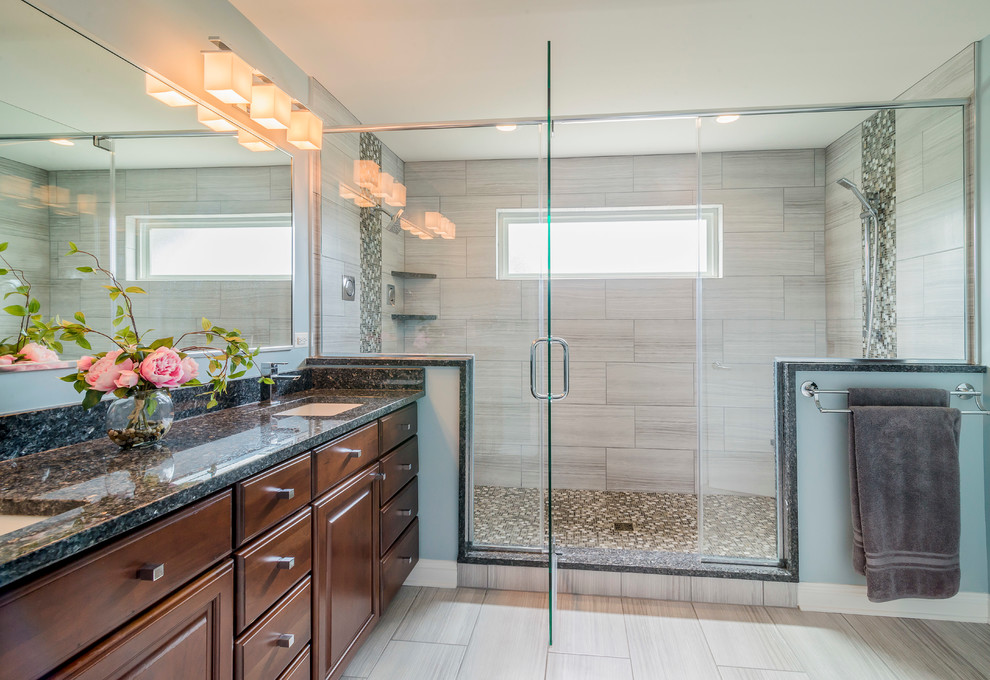 Example of a large transitional master gray tile and porcelain tile porcelain tile and beige floor alcove shower design in Chicago with an undermount sink, raised-panel cabinets, dark wood cabinets, granite countertops, a two-piece toilet, blue walls and a hinged shower door