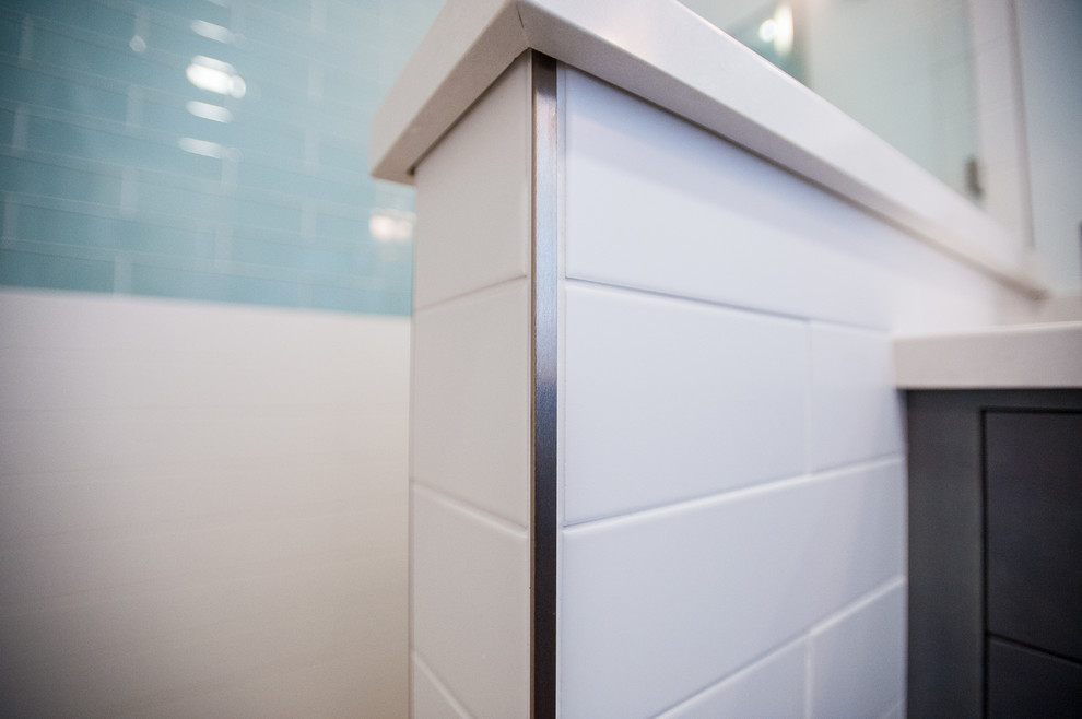 Klassisk inredning av ett badrum, med en dusch i en alkov, blå kakel, vit kakel, tunnelbanekakel och klinkergolv i småsten