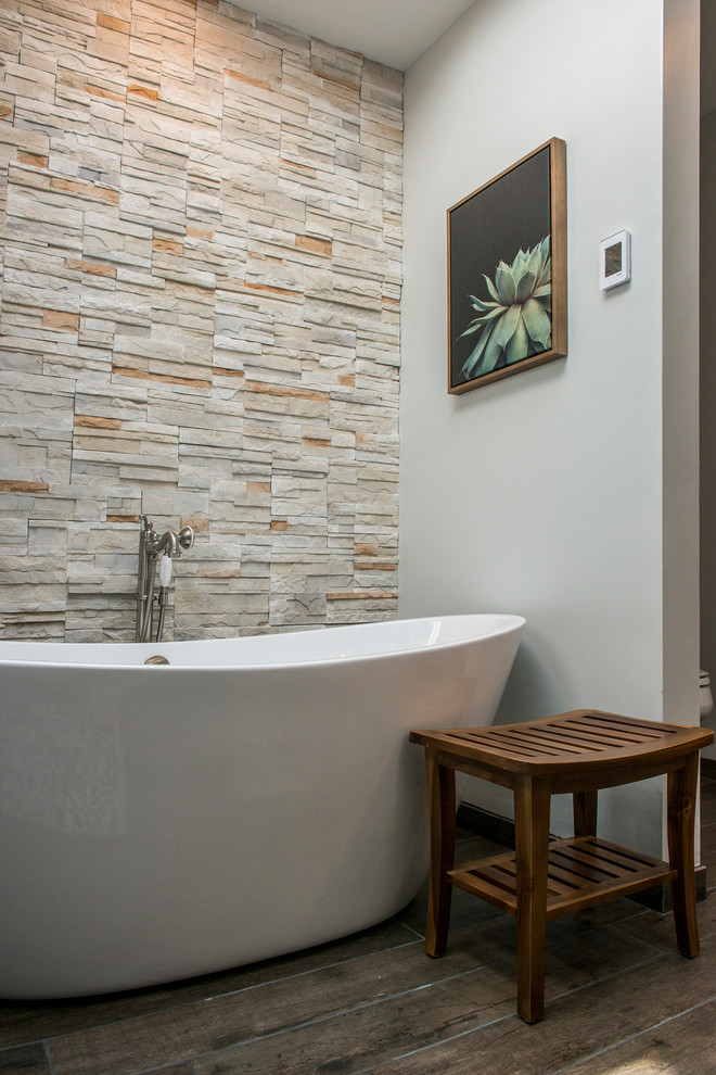 Photo of a medium sized traditional ensuite bathroom in Kansas City with flat-panel cabinets, brown cabinets, a freestanding bath, an alcove shower, grey walls, dark hardwood flooring, a submerged sink, marble worktops, brown floors, a sliding door and white worktops.