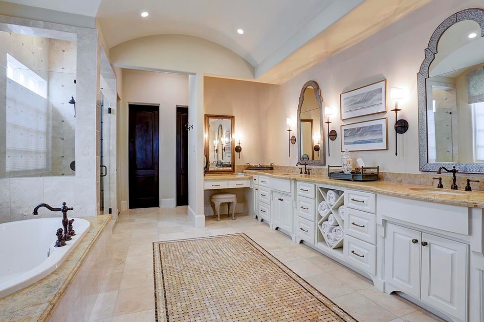 Inspiration for a large mediterranean master beige tile and ceramic tile ceramic tile bathroom remodel in Houston with raised-panel cabinets, white cabinets, beige walls and a drop-in sink