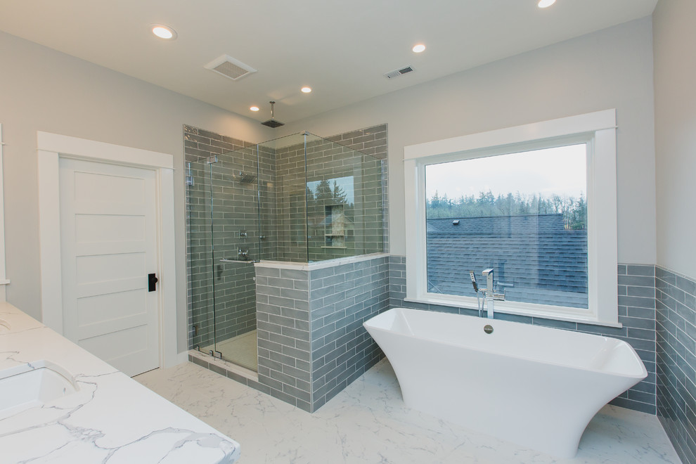 Design ideas for a large traditional ensuite bathroom in Seattle with shaker cabinets, a freestanding bath, a corner shower, grey tiles, metro tiles, grey walls, porcelain flooring, engineered stone worktops, white floors and white worktops.