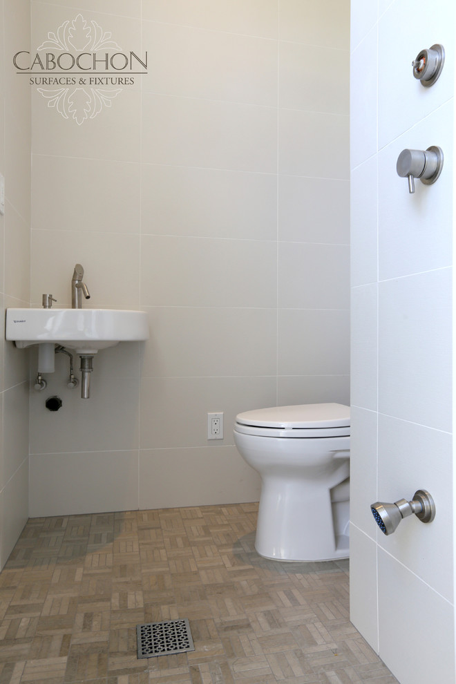 Пример оригинального дизайна: ванная комната среднего размера в стиле неоклассика (современная классика) с подвесной раковиной, открытым душем, раздельным унитазом, белой плиткой, керамогранитной плиткой, белыми стенами, полом из известняка и душевой кабиной
