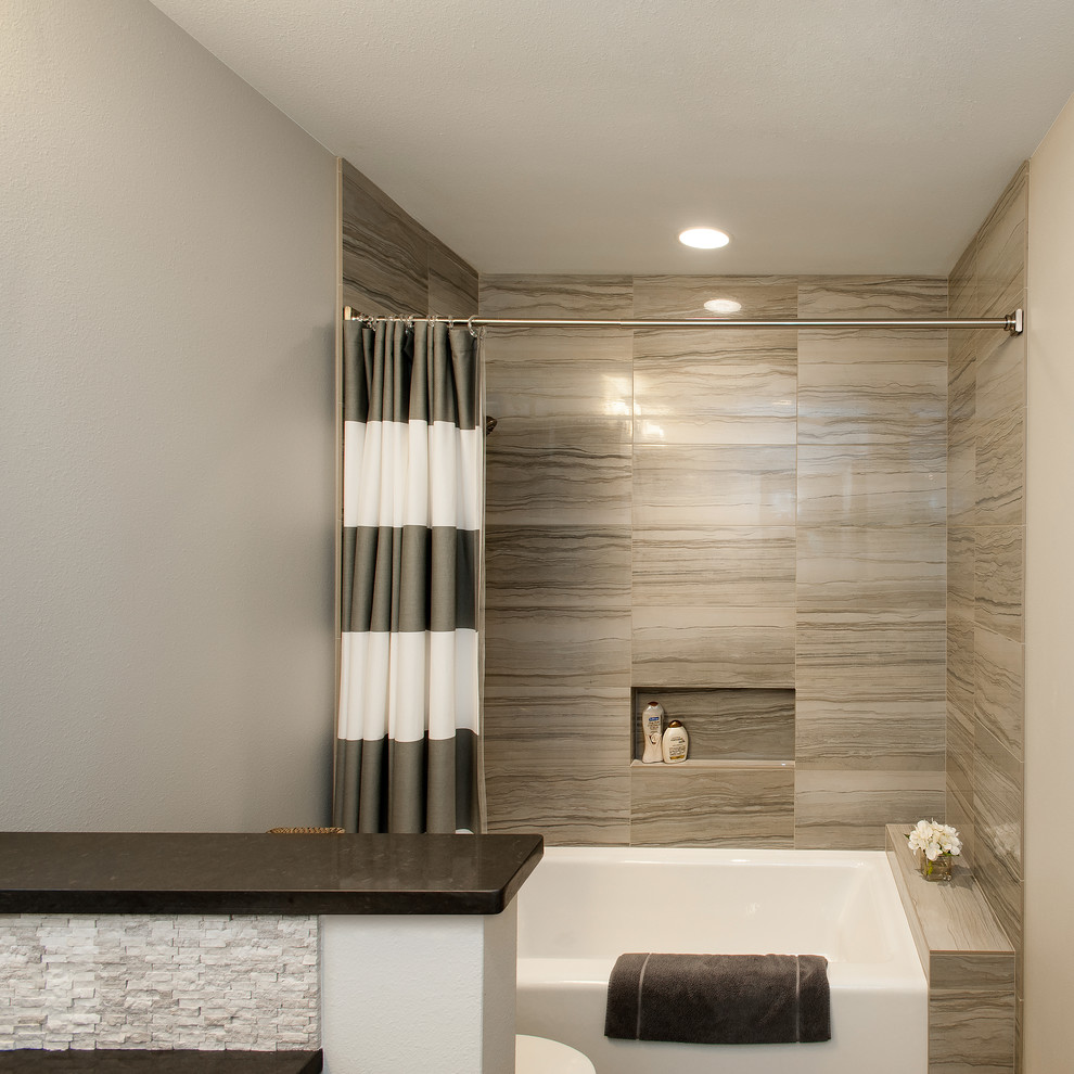 Foto di una stanza da bagno padronale tradizionale di medie dimensioni con lavabo sottopiano, top in superficie solida, vasca/doccia, piastrelle grigie, piastrelle in pietra e pareti bianche