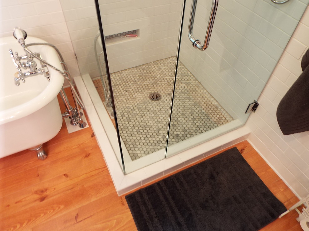 Inspiration for a medium sized classic ensuite bathroom in Miami with a wall-mounted sink, a freestanding bath, a corner shower, white tiles, louvered cabinets, dark wood cabinets, a two-piece toilet, metro tiles, medium hardwood flooring, wooden worktops, grey walls, brown floors, a hinged door and brown worktops.