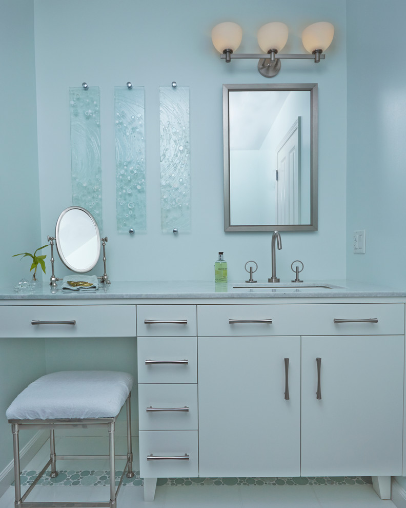 Пример оригинального дизайна: ванная комната среднего размера в стиле неоклассика (современная классика) с врезной раковиной, плоскими фасадами, белыми фасадами, синей плиткой, синими стенами, мраморной столешницей и стеклянной плиткой