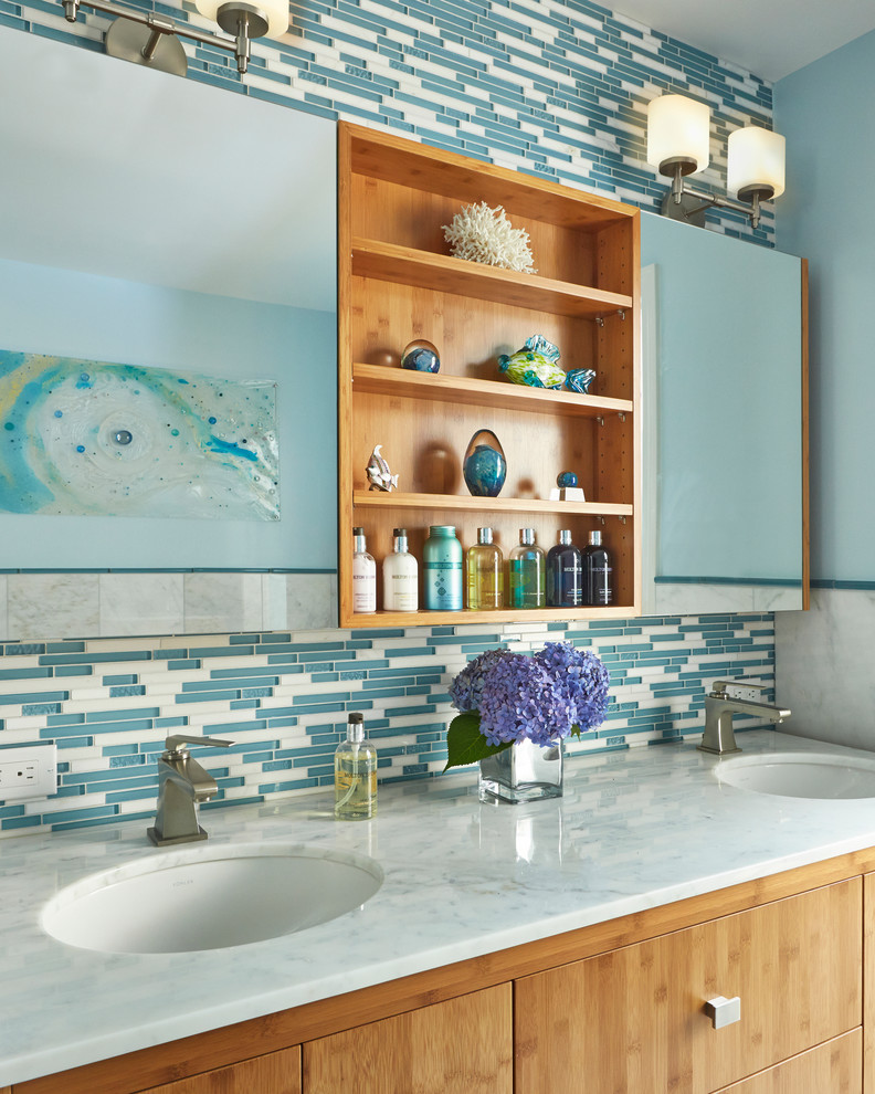 Inspiration pour une salle de bain principale traditionnelle en bois brun de taille moyenne avec un lavabo encastré, un placard à porte plane, une baignoire indépendante, une douche d'angle, WC à poser, un carrelage bleu, un mur bleu, un plan de toilette en marbre, un carrelage en pâte de verre et un sol en marbre.