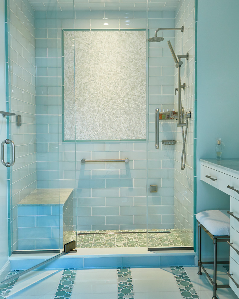 Modelo de cuarto de baño tradicional renovado de tamaño medio con lavabo bajoencimera, armarios con paneles lisos, puertas de armario blancas, ducha empotrada, sanitario de una pieza, baldosas y/o azulejos azules, paredes azules, encimera de mármol y baldosas y/o azulejos de vidrio
