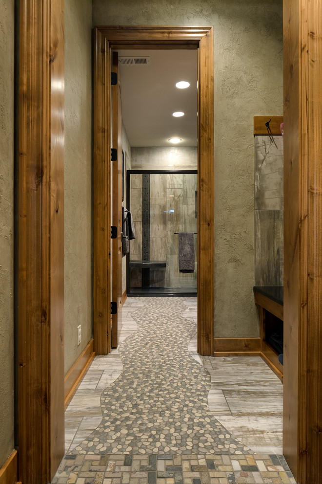 Foto på ett stort rustikt badrum med dusch, med luckor med infälld panel, skåp i mellenmörkt trä, en dusch i en alkov, grå kakel, stenkakel, gröna väggar, klinkergolv i småsten, ett undermonterad handfat och granitbänkskiva