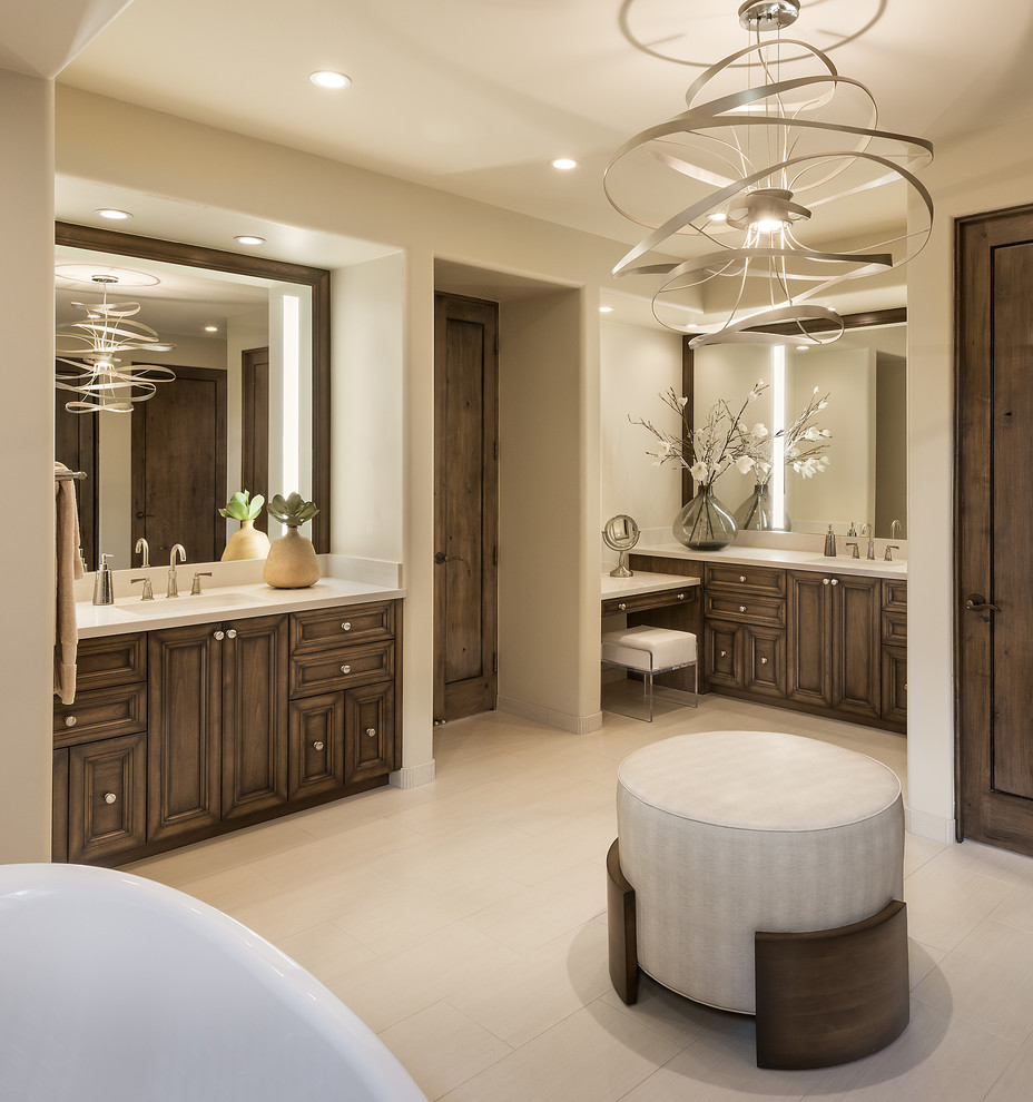 Photo of a medium sized traditional bathroom in Phoenix with recessed-panel cabinets, medium wood cabinets, a freestanding bath, a walk-in shower, a one-piece toilet, beige tiles, beige walls, porcelain flooring, a submerged sink, engineered stone worktops, beige floors and an open shower.