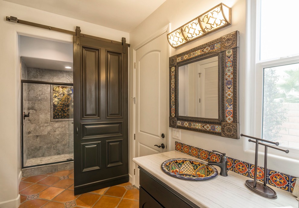 Photo of a bathroom in San Diego with flat-panel cabinets, dark wood cabinets, an alcove shower, multi-coloured tiles, ceramic tiles, beige walls, travertine flooring, a built-in sink, soapstone worktops, brown floors and a hinged door.