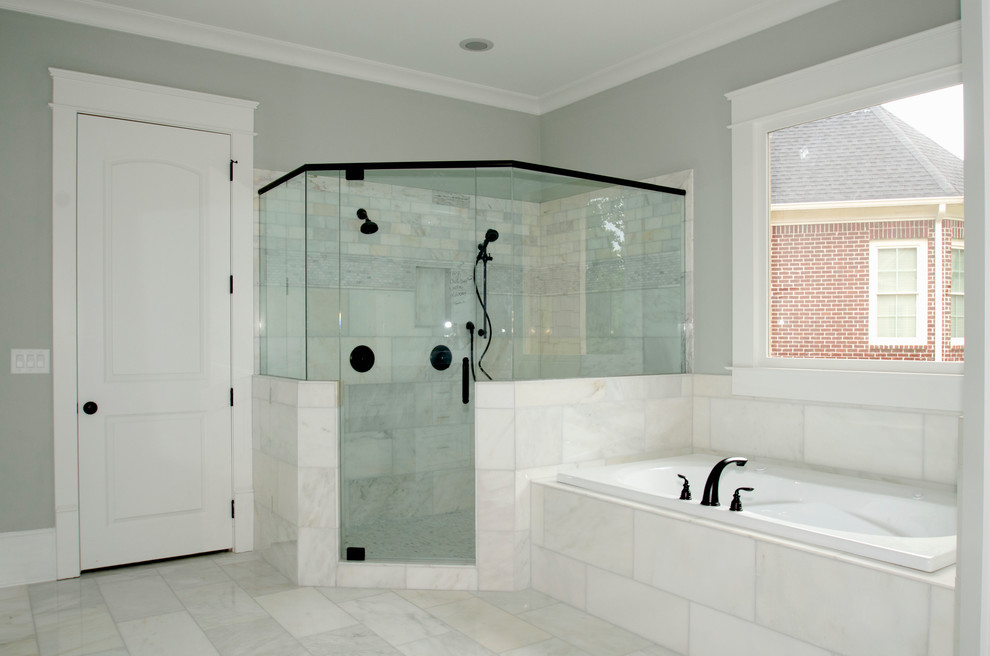 Exemple d'une grande salle de bain principale chic avec un lavabo encastré, un placard avec porte à panneau surélevé, des portes de placard blanches, un plan de toilette en granite, un bain bouillonnant, une douche d'angle, WC séparés, un carrelage blanc, un carrelage de pierre, un mur gris et un sol en marbre.