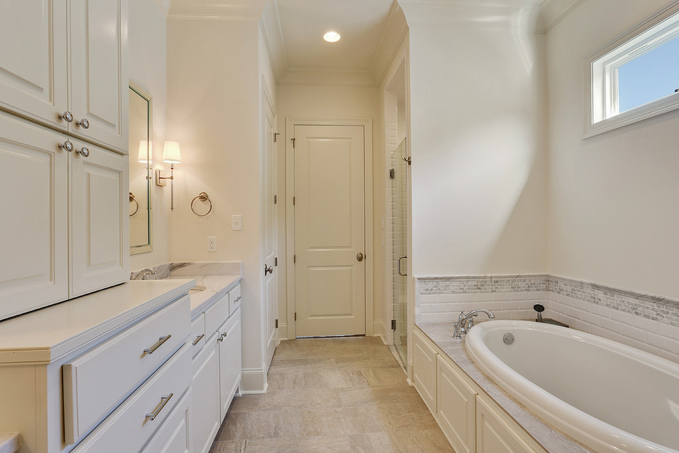 Example of a mid-sized transitional master white tile and ceramic tile vinyl floor bathroom design in New Orleans with raised-panel cabinets, white cabinets, a drop-in sink, granite countertops and white walls