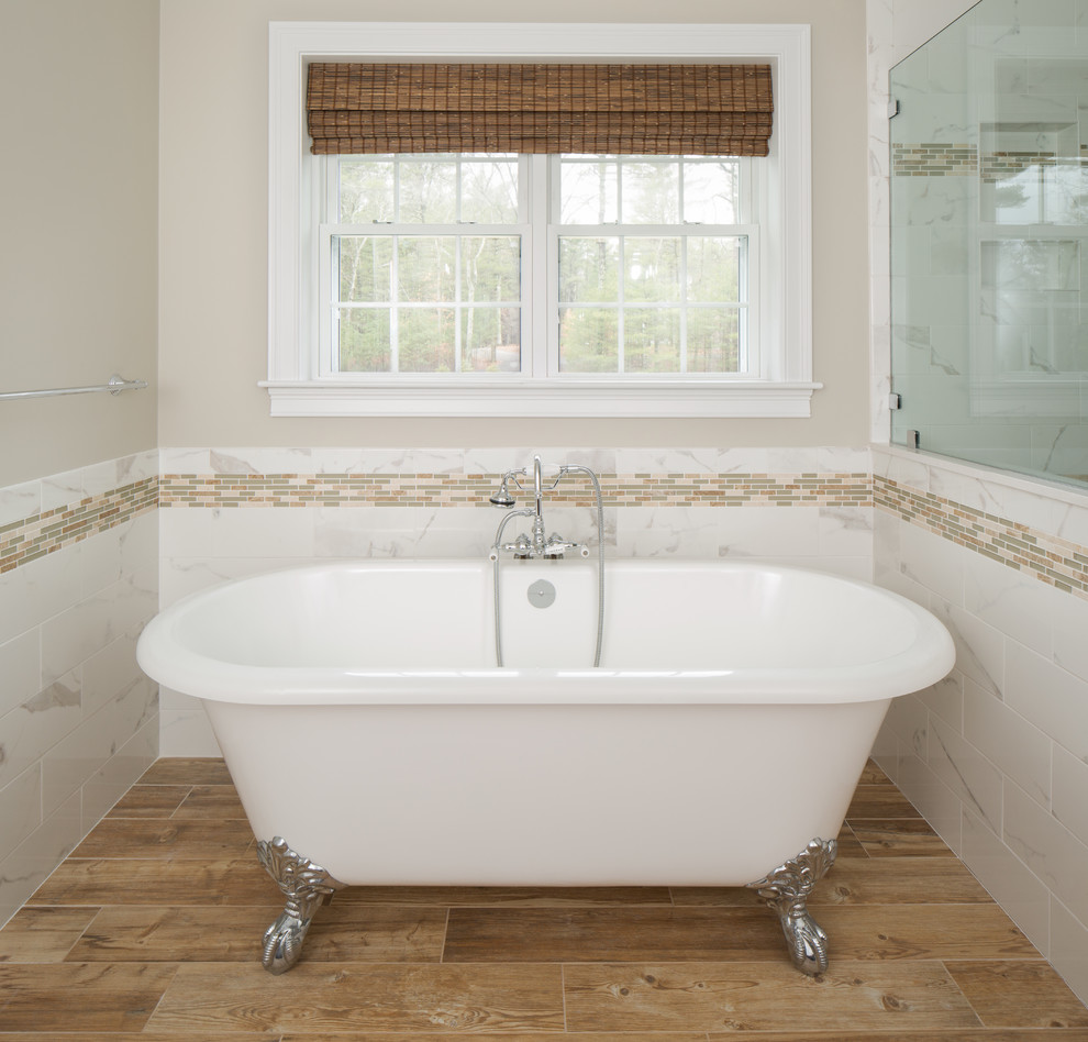 Foto på ett stort vintage en-suite badrum, med luckor med infälld panel, ett fristående badkar, ljust trägolv, brun kakel och porslinskakel
