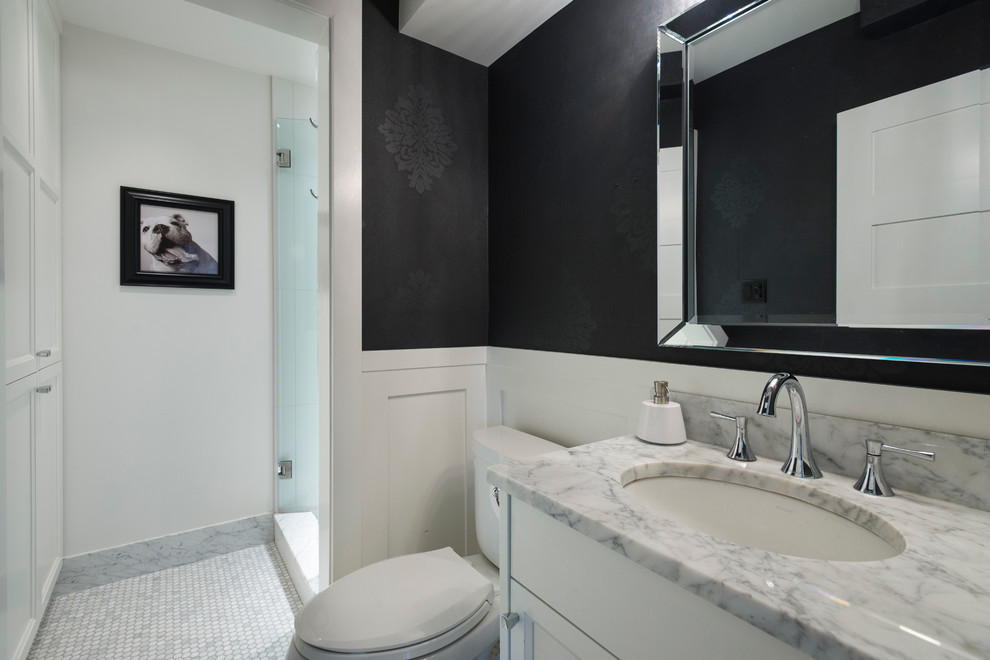 Inspiration pour une salle de bain traditionnelle de taille moyenne avec un placard à porte shaker, des portes de placard blanches, WC séparés, un carrelage blanc, un carrelage de pierre, un mur noir, un sol en marbre, un lavabo encastré et un plan de toilette en marbre.