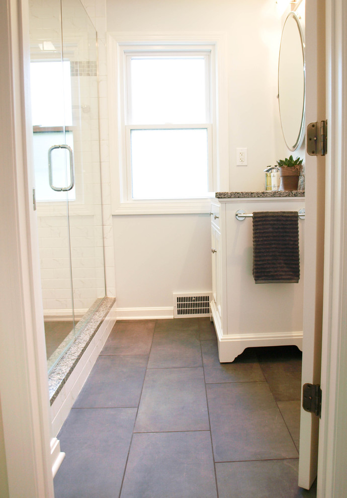 Cette image montre une salle de bain principale traditionnelle de taille moyenne avec un placard à porte shaker, des portes de placard blanches, une baignoire en alcôve, un combiné douche/baignoire, WC séparés, un carrelage blanc, des carreaux de céramique, un mur blanc, un sol en carrelage de porcelaine, un lavabo encastré et un plan de toilette en granite.