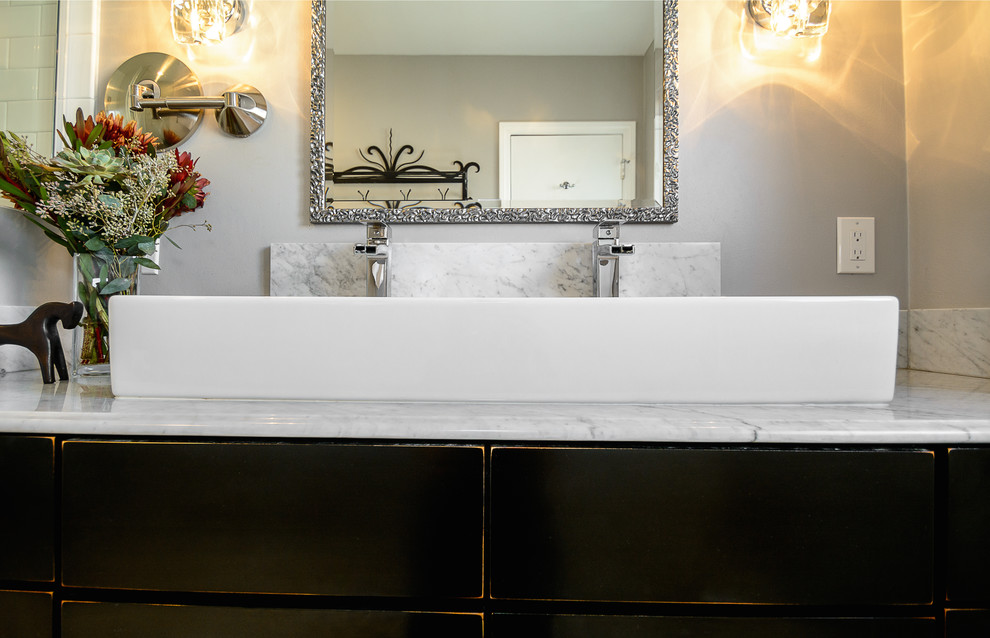 Modelo de cuarto de baño tradicional renovado de tamaño medio con puertas de armario negras, sanitario de una pieza, baldosas y/o azulejos en mosaico, paredes blancas, lavabo de seno grande y encimera de mármol
