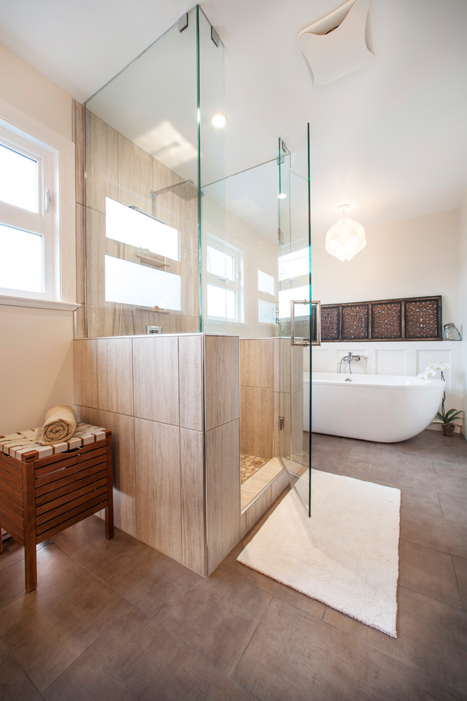 Klassisk inredning av ett stort en-suite badrum, med ett fristående badkar, en dusch i en alkov, beige kakel, porslinskakel, beige väggar, klinkergolv i porslin, brunt golv och dusch med gångjärnsdörr