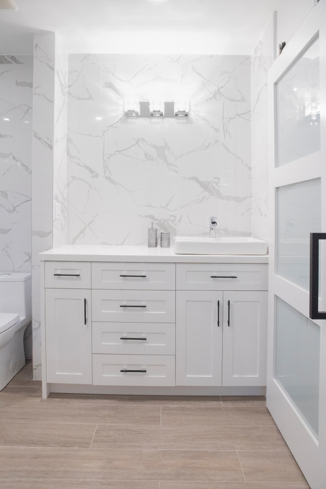 Inredning av ett klassiskt stort vit vitt badrum med dusch, med skåp i shakerstil, vita skåp, en toalettstol med hel cisternkåpa, vit kakel, keramikplattor, vita väggar, ett konsol handfat och bänkskiva i kvarts