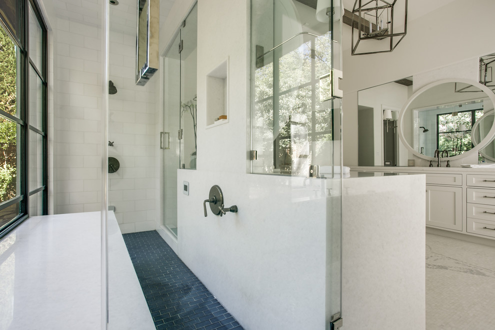 На фото: огромная главная ванная комната в стиле неоклассика (современная классика) с фасадами в стиле шейкер, белыми фасадами, накладной ванной, двойным душем, белой плиткой, белыми стенами, полом из мозаичной плитки, врезной раковиной, мраморной столешницей и плиткой мозаикой