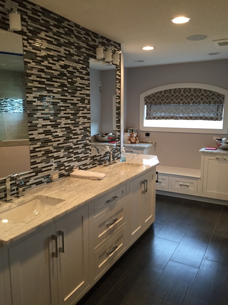 Example of a mid-sized transitional master multicolored tile and glass sheet ceramic tile doorless shower design in Jacksonville with beaded inset cabinets, white cabinets, a one-piece toilet, gray walls, an undermount sink and quartz countertops