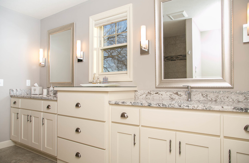 Modelo de cuarto de baño principal tradicional renovado con armarios estilo shaker, puertas de armario blancas, paredes grises, suelo de baldosas de cerámica, lavabo bajoencimera y encimera de granito