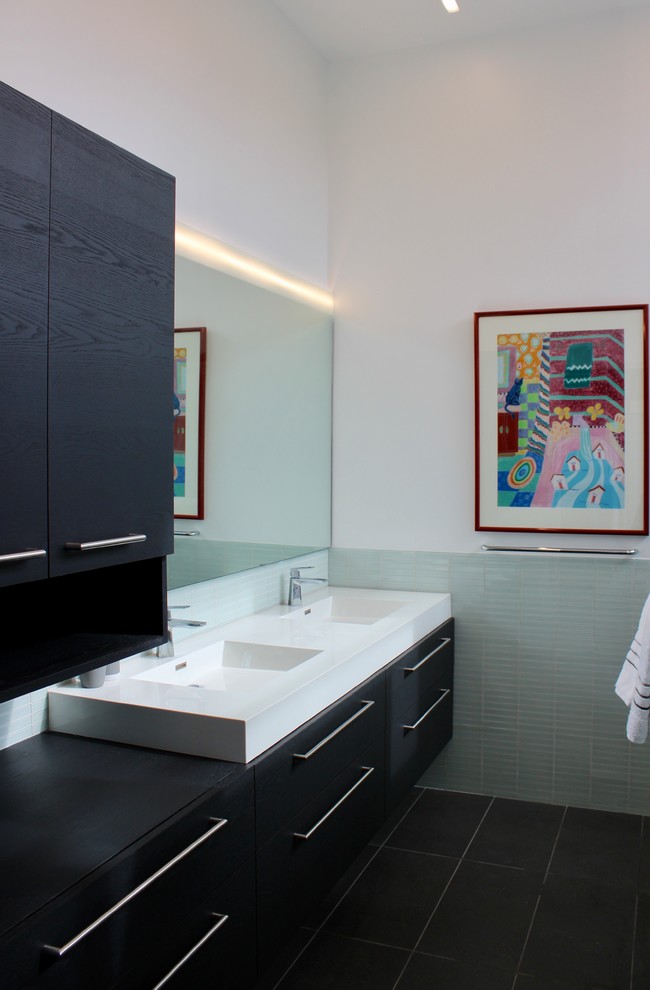Modern inredning av ett mellanstort vit vitt en-suite badrum, med släta luckor, svarta skåp, en kantlös dusch, en toalettstol med hel cisternkåpa, vit kakel, glaskakel, vita väggar, klinkergolv i porslin, ett integrerad handfat, grått golv och med dusch som är öppen