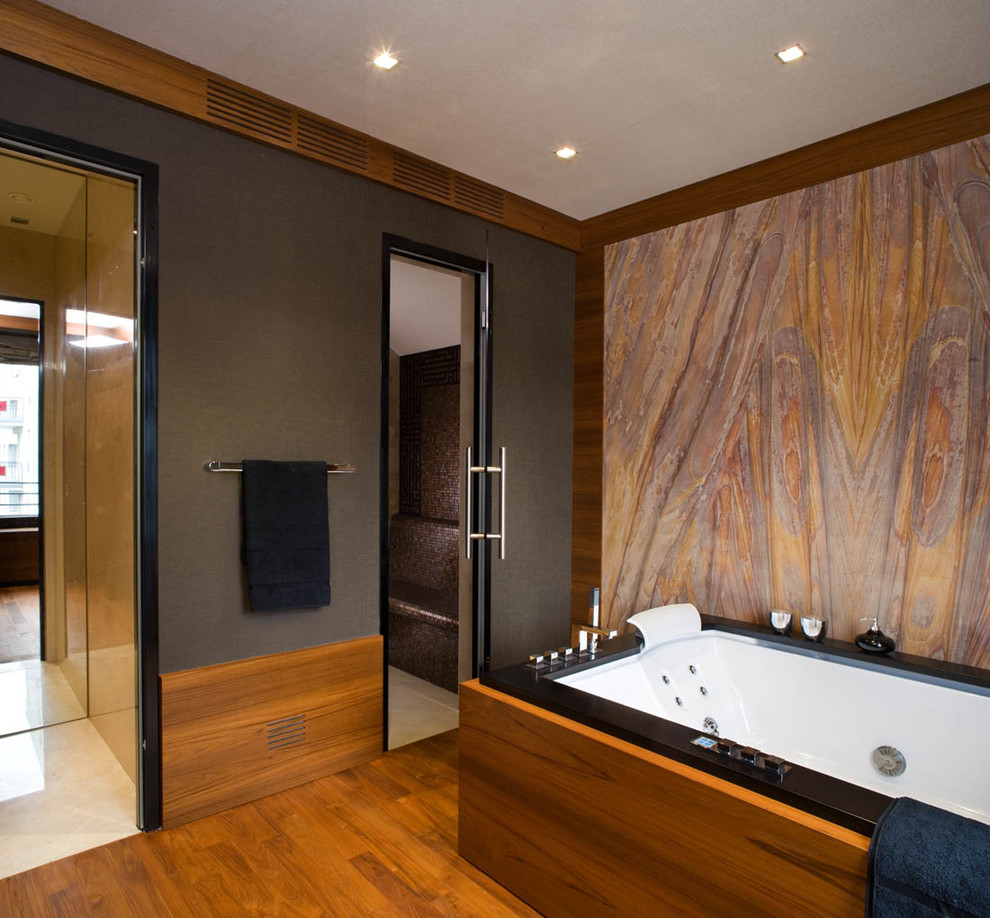 На фото: ванная комната в современном стиле с полновстраиваемой ванной, коричневой плиткой и плиткой мозаикой с