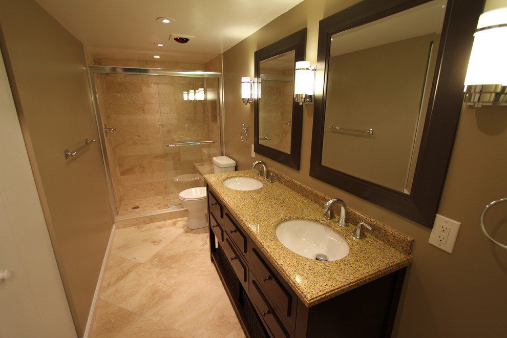 Idéer för ett mellanstort klassiskt en-suite badrum, med ett undermonterad handfat, möbel-liknande, skåp i mörkt trä, granitbänkskiva, en dusch i en alkov, en toalettstol med separat cisternkåpa, beige kakel, stenkakel, bruna väggar, travertin golv och beiget golv