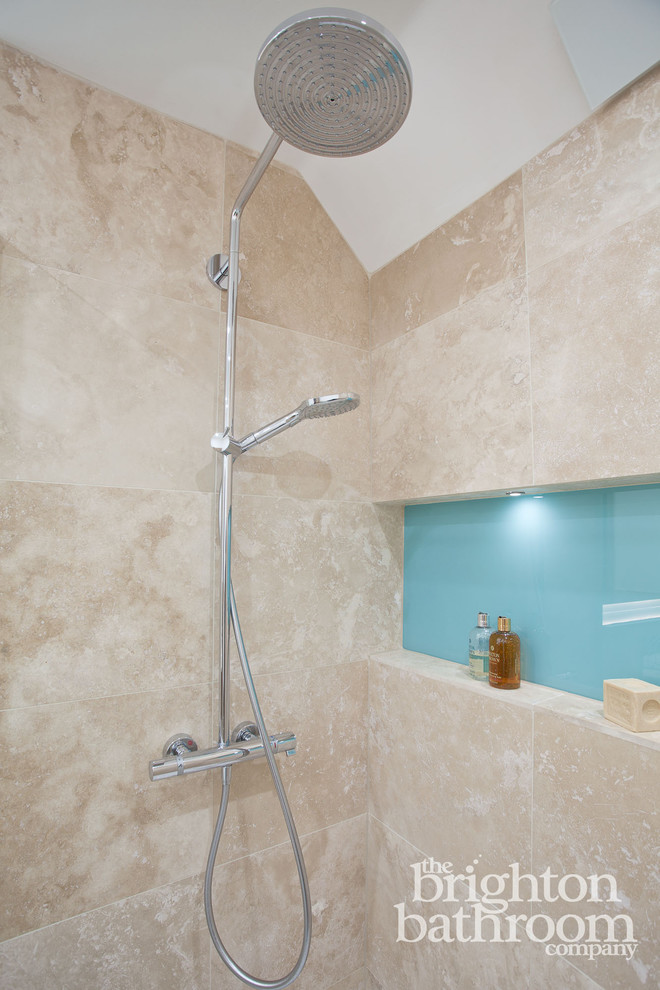 Medium sized traditional ensuite bathroom in Sussex with freestanding cabinets, dark wood cabinets, a walk-in shower, a one-piece toilet, beige tiles, stone tiles, beige walls, travertine flooring and a built-in sink.