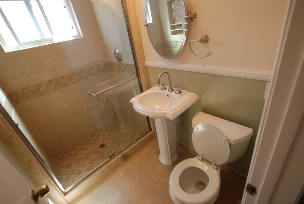 Kleines Klassisches Badezimmer mit Sockelwaschbecken, Wandtoilette mit Spülkasten, beigen Fliesen, Steinfliesen, grüner Wandfarbe und Porzellan-Bodenfliesen in Orange County