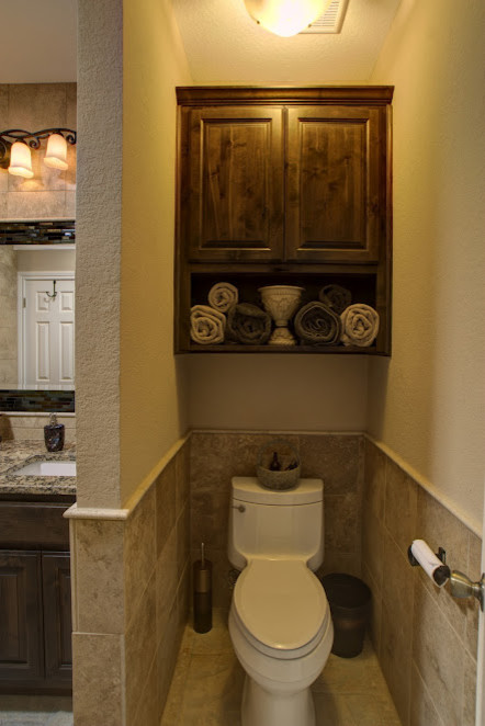 Inspiration for a timeless stone tile powder room remodel in Austin with flat-panel cabinets and a one-piece toilet