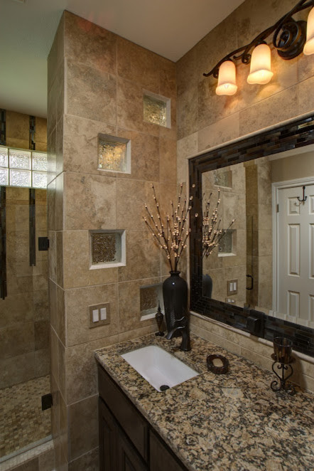 Diseño de cuarto de baño tradicional con lavabo bajoencimera, armarios con paneles lisos, puertas de armario de madera en tonos medios, encimera de granito, ducha empotrada y baldosas y/o azulejos de vidrio