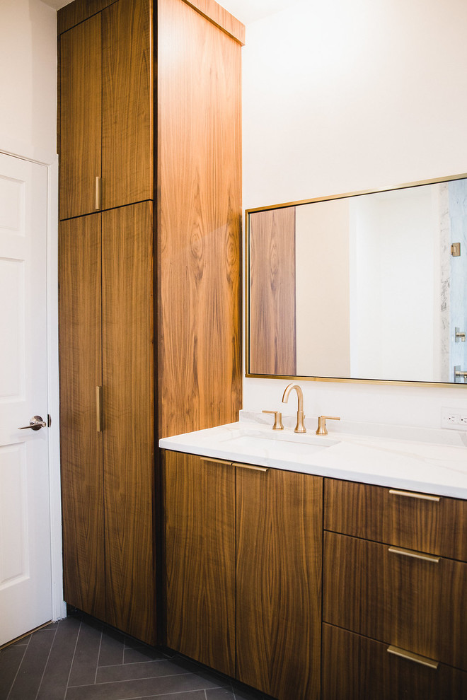 Aménagement d'une salle d'eau moderne en bois brun de taille moyenne avec un placard à porte plane, un mur blanc, un sol en carrelage de céramique, un lavabo encastré, un plan de toilette en quartz et un sol gris.