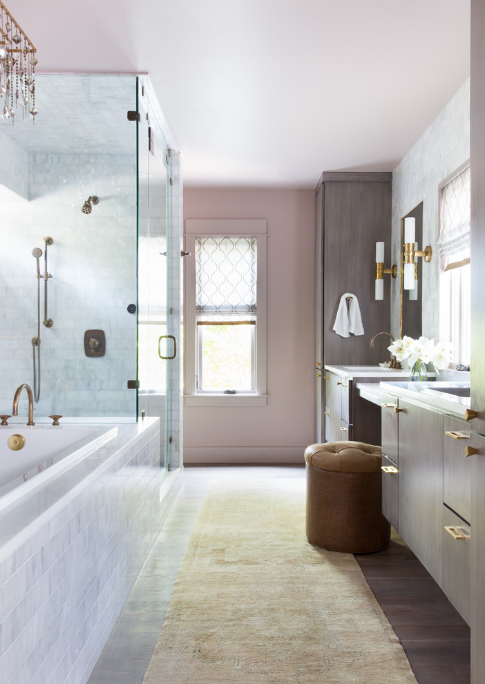 Exempel på ett mellanstort klassiskt vit vitt en-suite badrum, med släta luckor, grå skåp, ett platsbyggt badkar, grå kakel, rosa väggar, ljust trägolv, ett integrerad handfat, bänkskiva i akrylsten, brunt golv och dusch med gångjärnsdörr