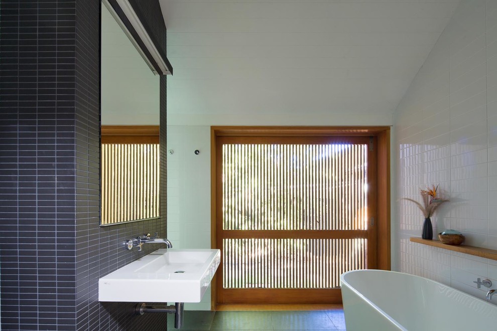 Источник вдохновения для домашнего уюта: главная ванная комната в современном стиле с отдельно стоящей ванной, открытым душем, черной плиткой, удлиненной плиткой, белыми стенами, подвесной раковиной и зеленым полом