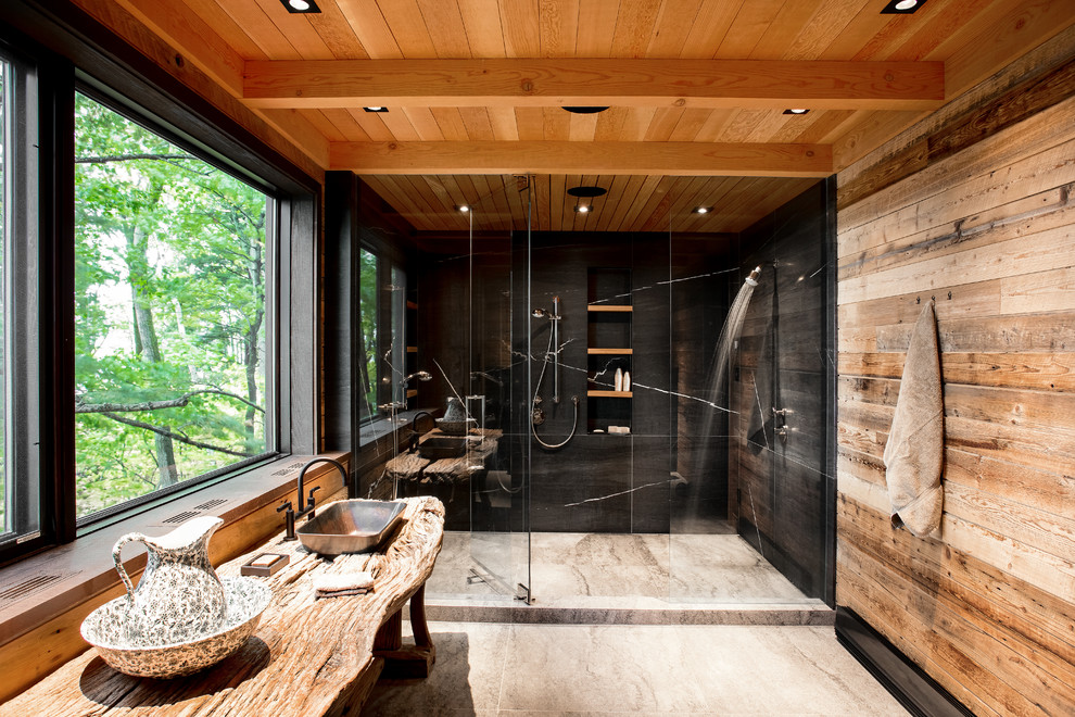 モントリオールにあるラスティックスタイルのおしゃれな浴室 (アルコーブ型シャワー、黒いタイル、ベッセル式洗面器、木製洗面台、グレーの床、開き戸のシャワー) の写真