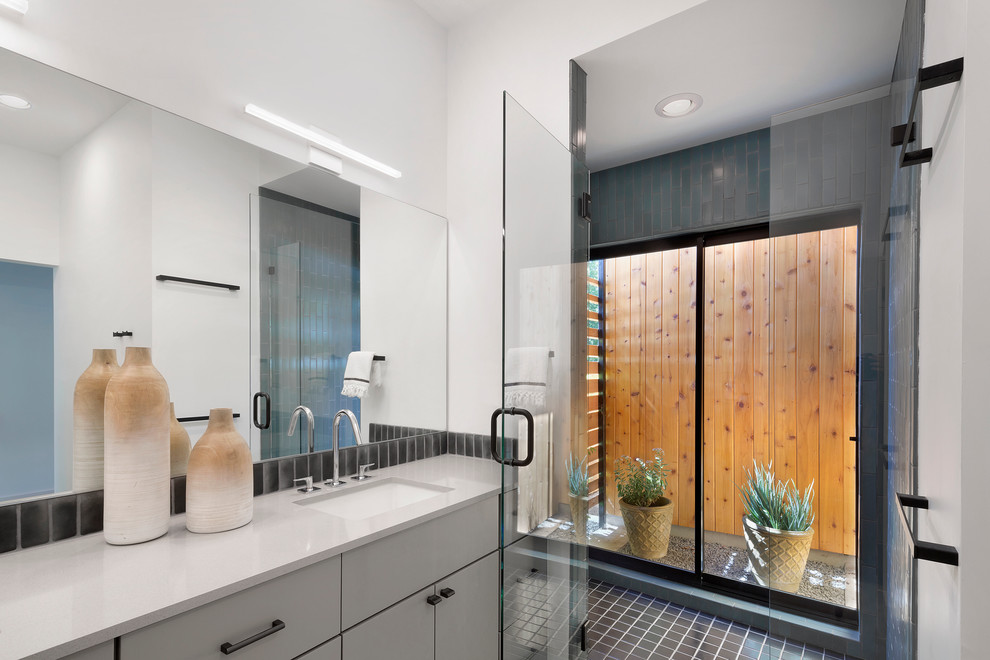 Idéer för mellanstora funkis en-suite badrum, med ett undermonterad handfat, släta luckor, grå skåp, bänkskiva i kvarts, en öppen dusch, en toalettstol med hel cisternkåpa, blå kakel, cementkakel, vita väggar och betonggolv