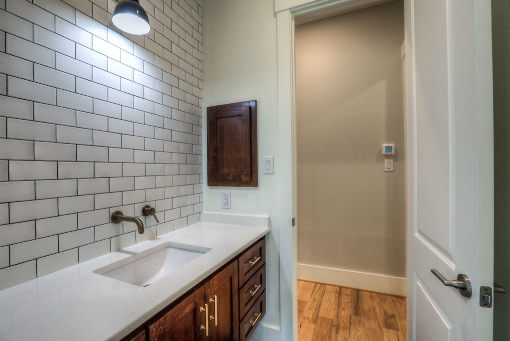 Inspiration for a mid-sized 1950s white tile and ceramic tile medium tone wood floor and brown floor bathroom remodel in Houston with recessed-panel cabinets, dark wood cabinets, a two-piece toilet, white walls, an undermount sink and quartz countertops