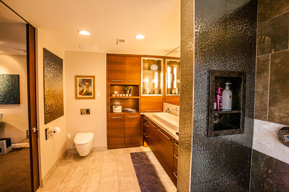 Bild på ett stort funkis en-suite badrum, med släta luckor, skåp i mellenmörkt trä, en öppen dusch, en bidé, grå kakel, keramikplattor, beige väggar, klinkergolv i porslin, ett avlångt handfat och granitbänkskiva