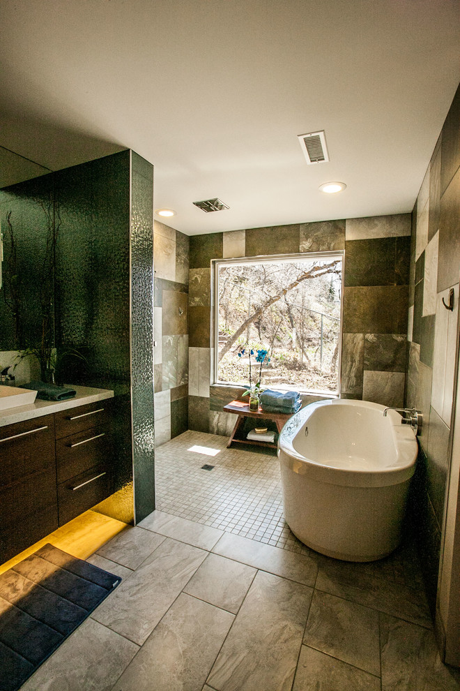 Réalisation d'une grande salle de bain principale minimaliste en bois brun avec un placard à porte plane, une douche ouverte, un bidet, un carrelage gris, des carreaux de céramique, un mur beige, un sol en carrelage de porcelaine, une grande vasque et un plan de toilette en granite.