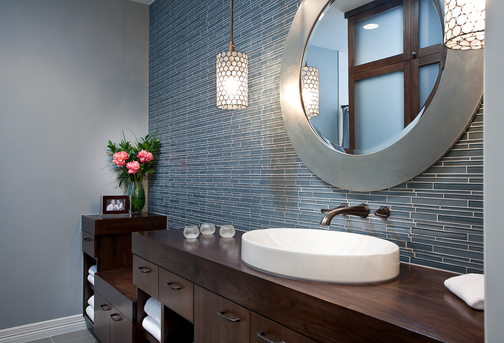 Пример оригинального дизайна: ванная комната в современном стиле с настольной раковиной, плоскими фасадами, темными деревянными фасадами, столешницей из дерева, синей плиткой и удлиненной плиткой