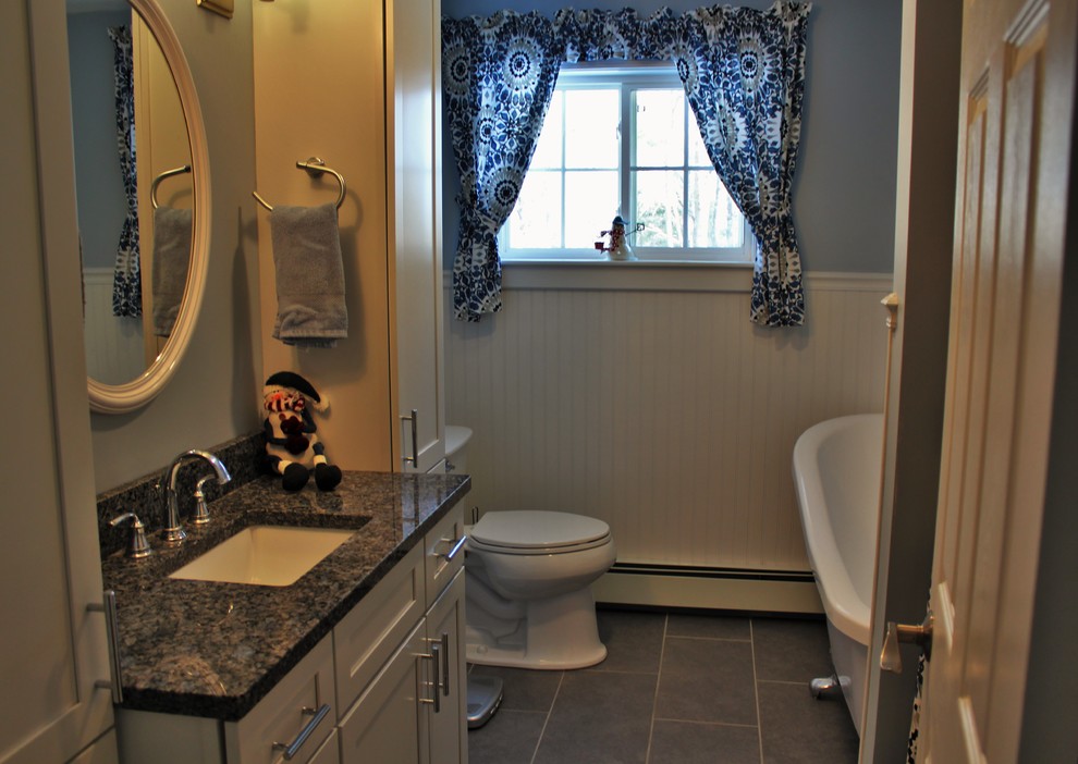 Réalisation d'une salle de bain principale champêtre de taille moyenne avec des portes de placard blanches, une baignoire sur pieds, WC à poser, un carrelage gris, des carreaux de céramique, un mur bleu, un sol en carrelage de céramique, un lavabo posé et un plan de toilette en granite.