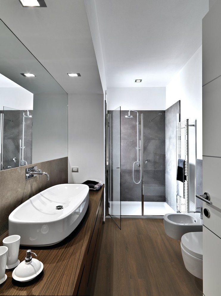 Idée de décoration pour une douche en alcôve principale minimaliste en bois brun de taille moyenne avec un placard à porte plane, un bidet, un mur blanc, un sol en vinyl, une grande vasque et un plan de toilette en bois.