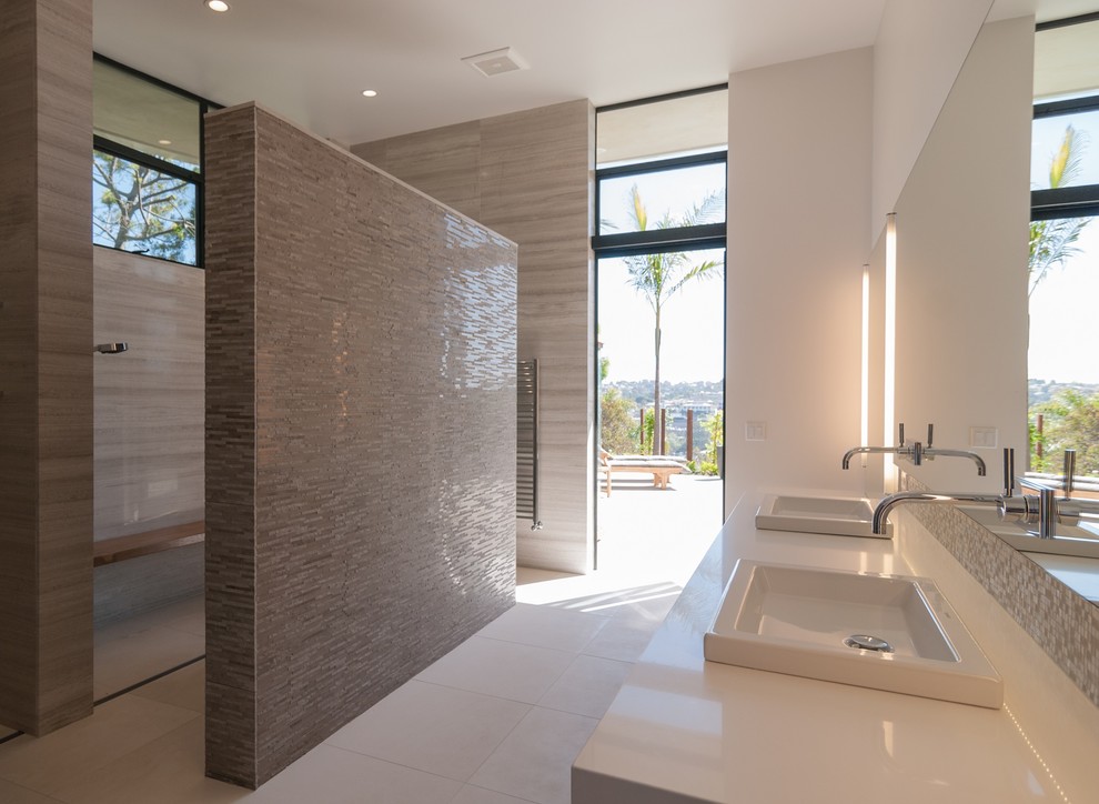 Inspiration for a large modern ensuite bathroom in San Diego with flat-panel cabinets, dark wood cabinets, a walk-in shower, beige tiles, stone tiles, white walls, ceramic flooring, a built-in sink and quartz worktops.