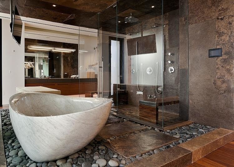 Пример оригинального дизайна: огромная главная ванная комната в стиле модернизм с фасадами цвета дерева среднего тона, двойным душем, коричневой плиткой, коричневыми стенами, плоскими фасадами, унитазом-моноблоком, плиткой из листового камня, полом из галечной плитки, монолитной раковиной, столешницей из искусственного кварца и отдельно стоящей ванной