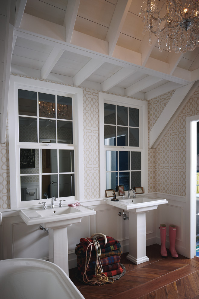 Bild på ett mellanstort vintage en-suite badrum, med ett fristående badkar, en toalettstol med hel cisternkåpa, vit kakel, flerfärgade väggar, mörkt trägolv, ett piedestal handfat, bänkskiva i akrylsten och brunt golv